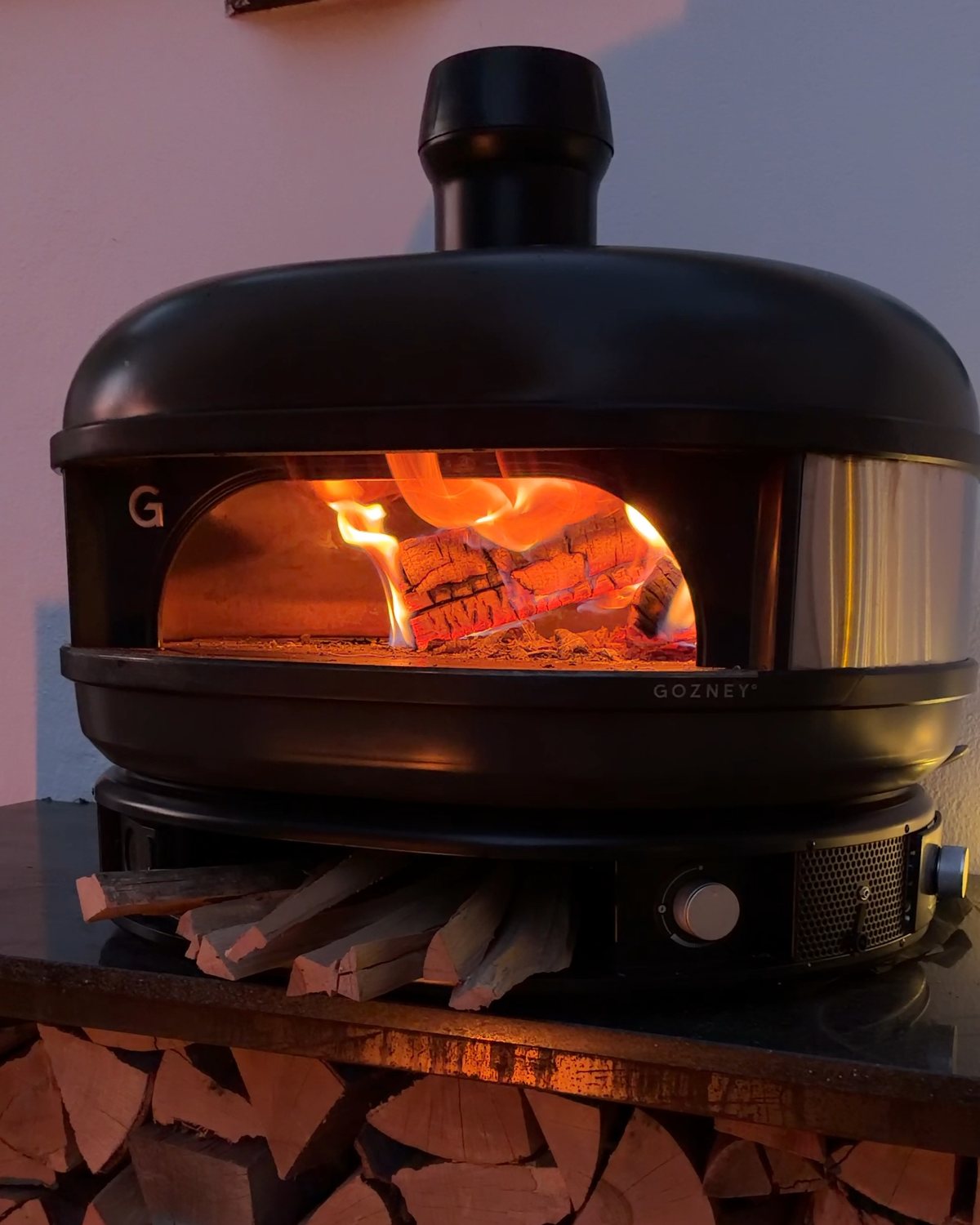 Pizzaofen auf der Granitplatte über dem Kaminholzregal aus Cortenstahl
